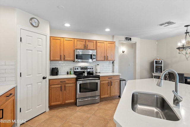 11042 W Case Way, Marana, AZ 85653 - kitchen featuring stainless steel appliances, a sink, decorative backsplash, light countertops, and light tile patterned flooring