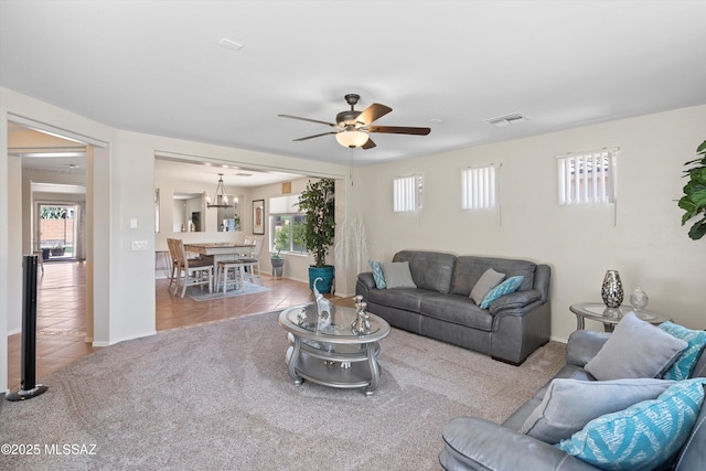 11042 W Case Way, Marana, AZ 85653 - tiled living area featuring healthy amount of natural light, a ceiling fan, carpet floors, and a chandelier