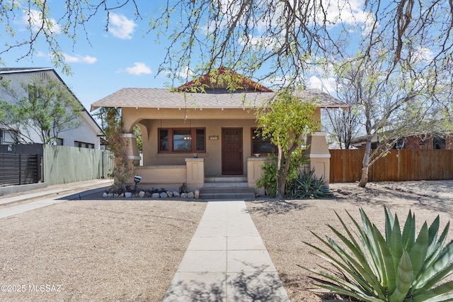 view of front of property with fence, stucco siding, and a porch