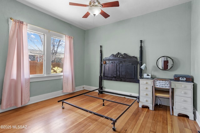 bedroom featuring baseboards, a ceiling fan, and hardwood / wood-style flooring