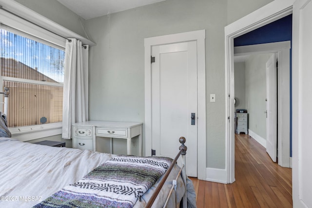 bedroom with baseboards and hardwood / wood-style floors