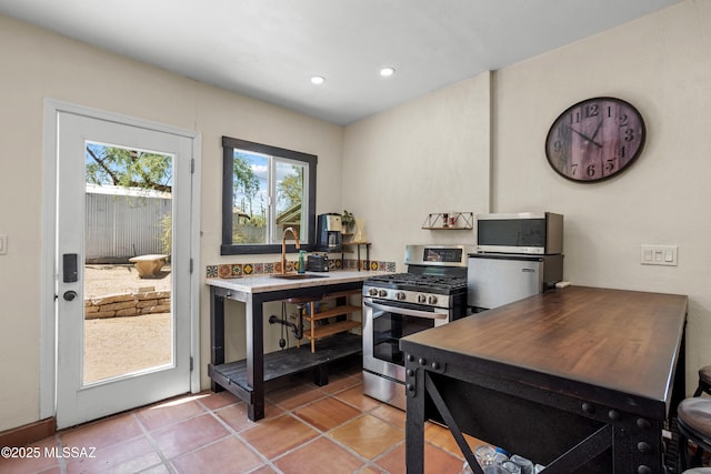 kitchen featuring recessed lighting, a sink, light tile patterned floors, and stainless steel appliances