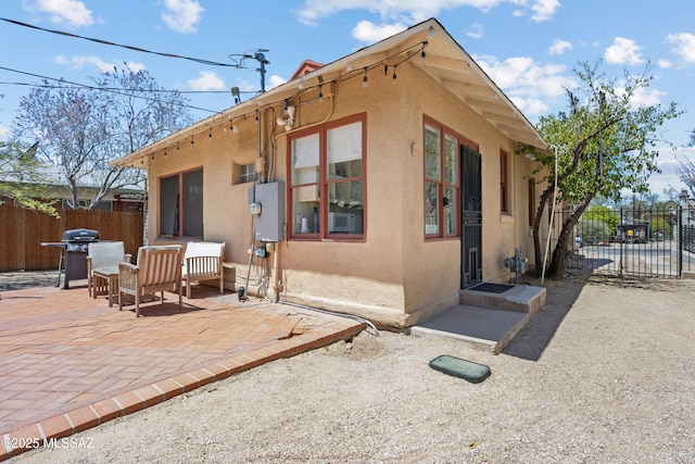 view of home's exterior featuring a patio, stucco siding, and fence