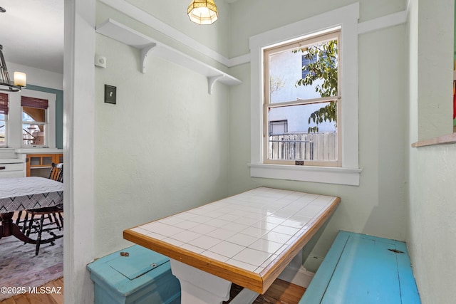 dining space with an inviting chandelier, wood finished floors, and a wealth of natural light