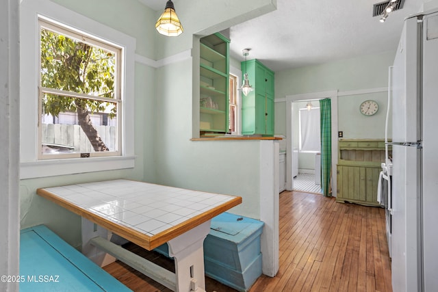 dining area with wood-type flooring and visible vents
