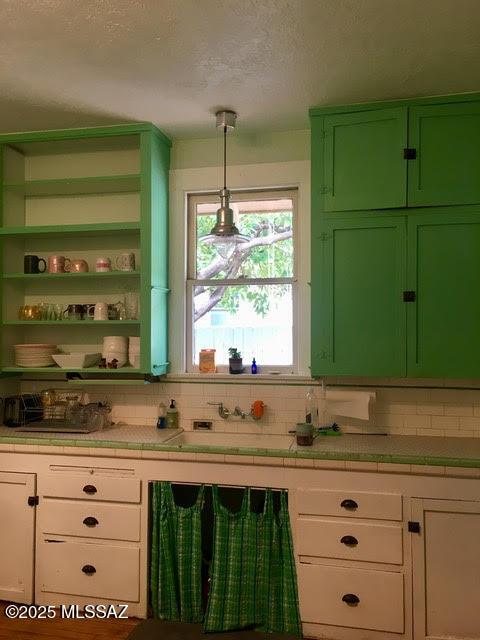 bar featuring pendant lighting, backsplash, and a textured ceiling