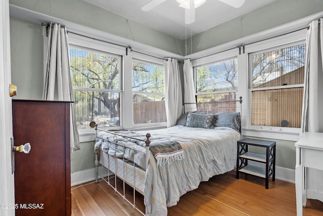 bedroom featuring baseboards, ceiling fan, and hardwood / wood-style flooring