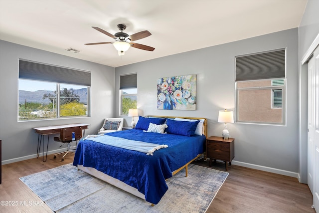 2868 N Silkie Pl, Tucson, AZ 85719 - bedroom with baseboards, multiple windows, and wood finished floors