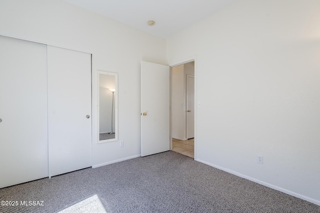 unfurnished bedroom with baseboards, carpet, and a closet
