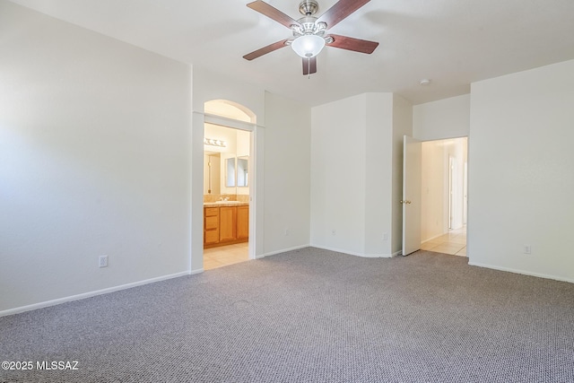 unfurnished bedroom featuring connected bathroom, baseboards, and light colored carpet
