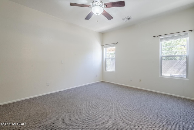 carpeted empty room featuring visible vents, baseboards, and ceiling fan