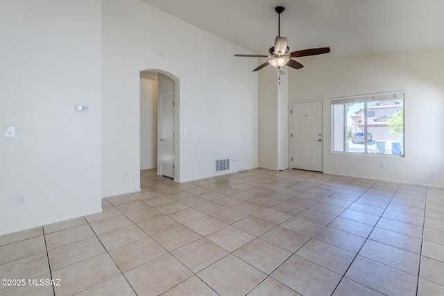 unfurnished room featuring a ceiling fan, visible vents, arched walkways, light tile patterned floors, and high vaulted ceiling