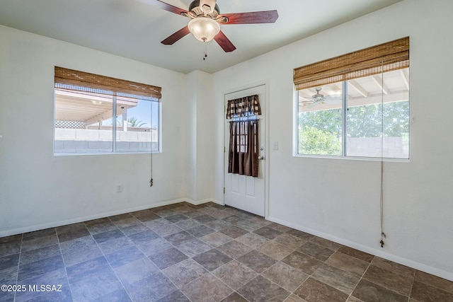foyer with a healthy amount of sunlight, stone finish floor, and baseboards
