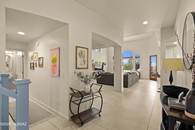 corridor featuring baseboards, recessed lighting, and light tile patterned flooring