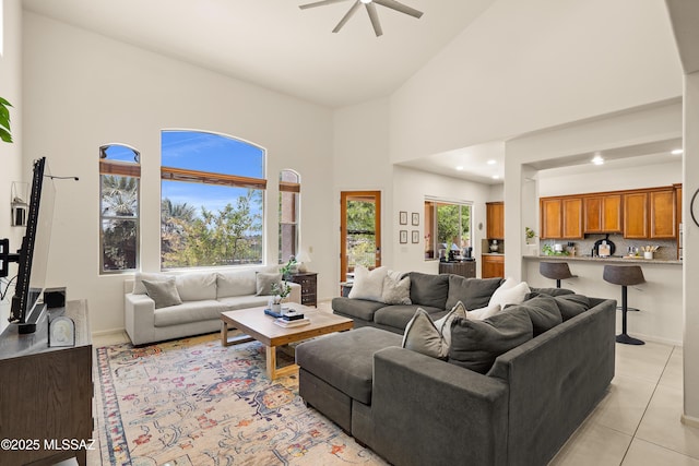 living room featuring a ceiling fan, a high ceiling, recessed lighting, and light tile patterned floors