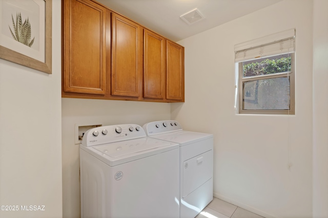 laundry room with independent washer and dryer, light tile patterned flooring, visible vents, and cabinet space