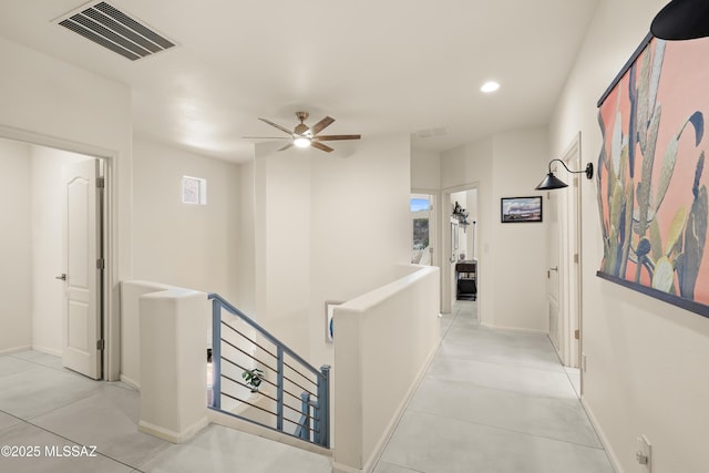 hallway with visible vents, recessed lighting, light tile patterned flooring, and an upstairs landing