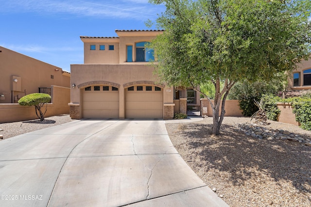 view of front of property featuring fence, an attached garage, stucco siding, a gate, and driveway