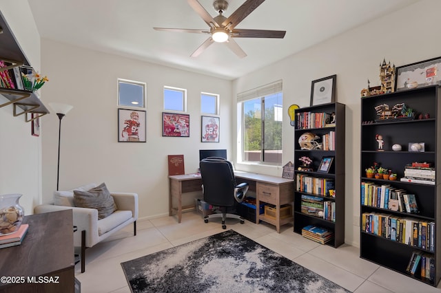 tiled office featuring a ceiling fan and baseboards