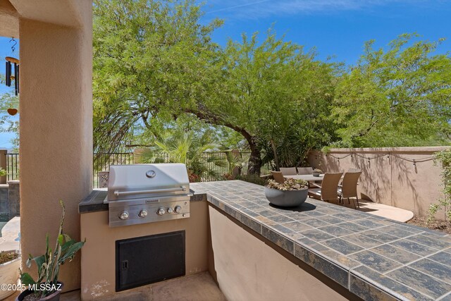 view of patio featuring a fenced backyard, an outdoor kitchen, and area for grilling