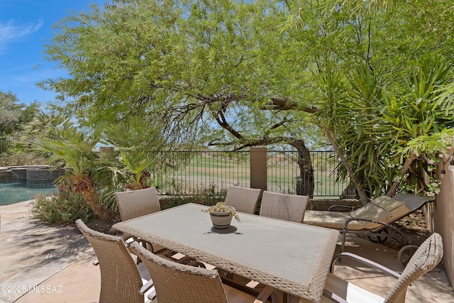 view of patio / terrace featuring fence, outdoor dining space, and a fenced in pool