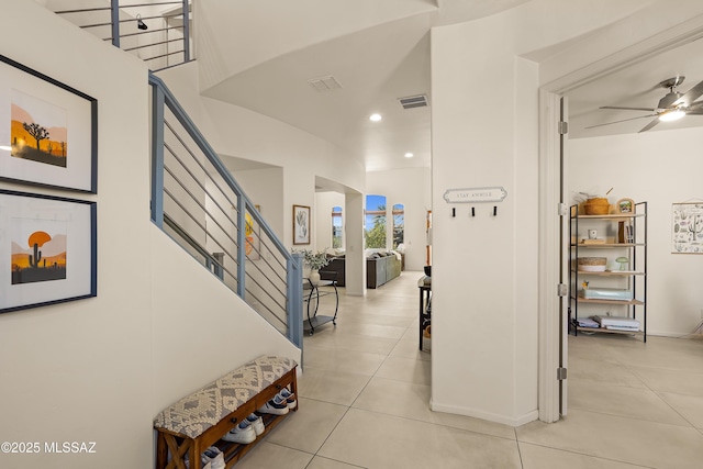 hall with arched walkways, stairs, recessed lighting, light tile patterned floors, and visible vents