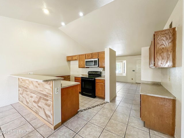 10084 E Bryonwood Ln, Tucson, AZ 85730 - kitchen featuring black range with electric cooktop, stainless steel microwave, a peninsula, light countertops, and brown cabinetry