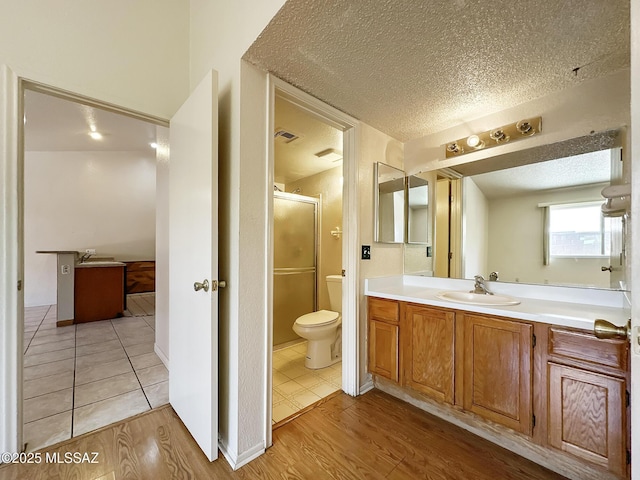 10084 E Bryonwood Ln, Tucson, AZ 85730 - full bath featuring a textured ceiling, vanity, a shower stall, and wood finished floors