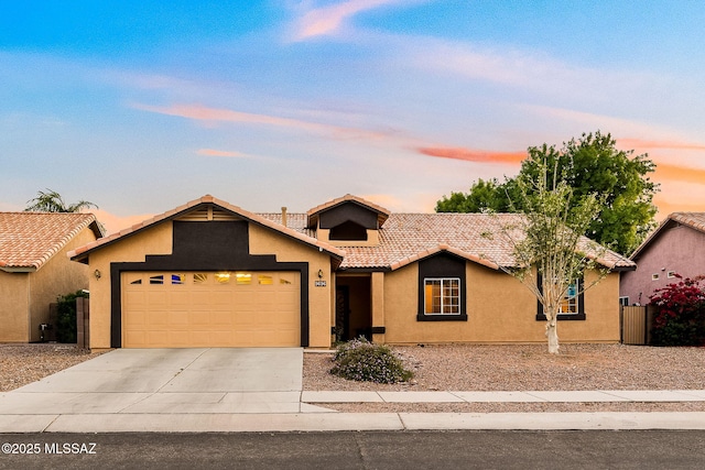 single story home with a garage, a tiled roof, concrete driveway, and stucco siding