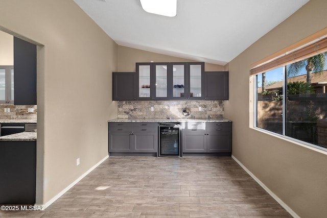 9696 E Paseo, San Rosendo, Tucson, AZ 85747 - bar featuring backsplash, beverage cooler, lofted ceiling, and light wood-style floors