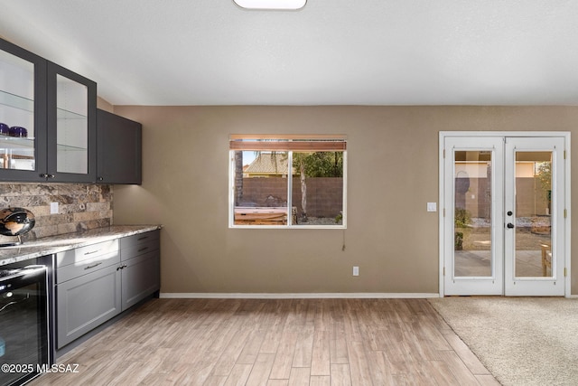 9696 E Paseo, San Rosendo, Tucson, AZ 85747 - interior space featuring french doors, light wood-style flooring, baseboards, decorative backsplash, and wine cooler