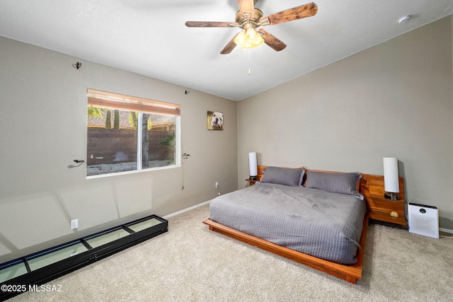 carpeted bedroom featuring baseboards and ceiling fan