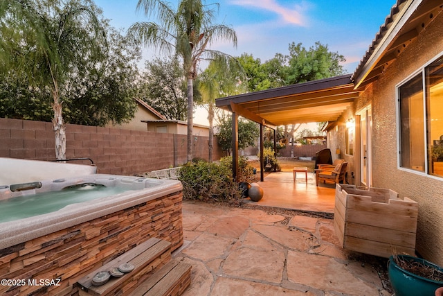 view of patio / terrace with a fenced backyard and a hot tub
