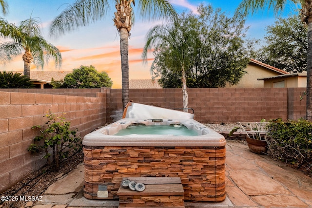 view of patio / terrace featuring a hot tub and a fenced backyard