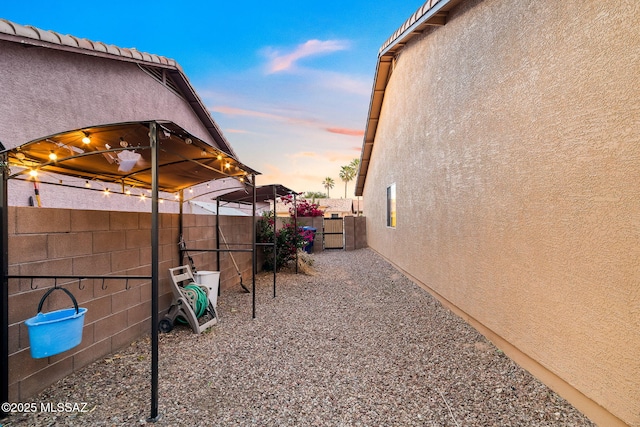 view of side of property featuring stucco siding and fence