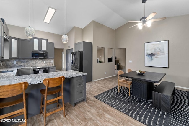 9696 E Paseo, San Rosendo, Tucson, AZ 85747 - kitchen with a sink, high vaulted ceiling, gray cabinets, stainless steel appliances, and backsplash