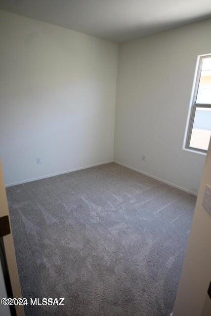 empty room featuring baseboards and carpet