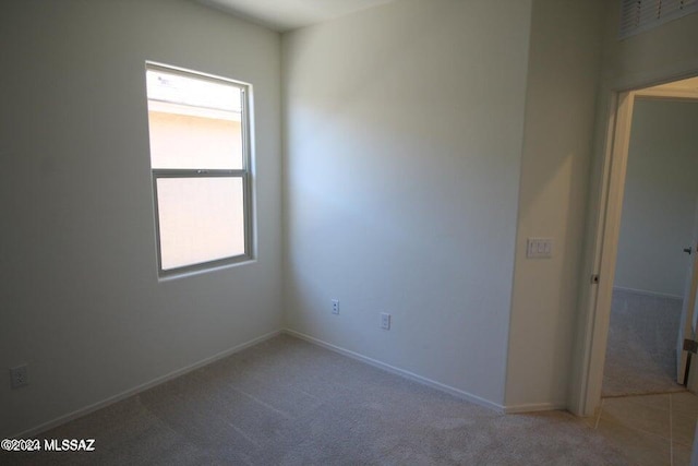 carpeted spare room with baseboards and a wealth of natural light