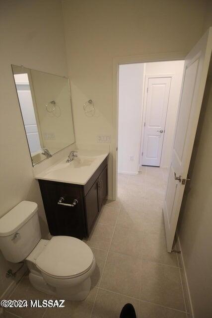 bathroom featuring vanity, tile patterned flooring, and toilet