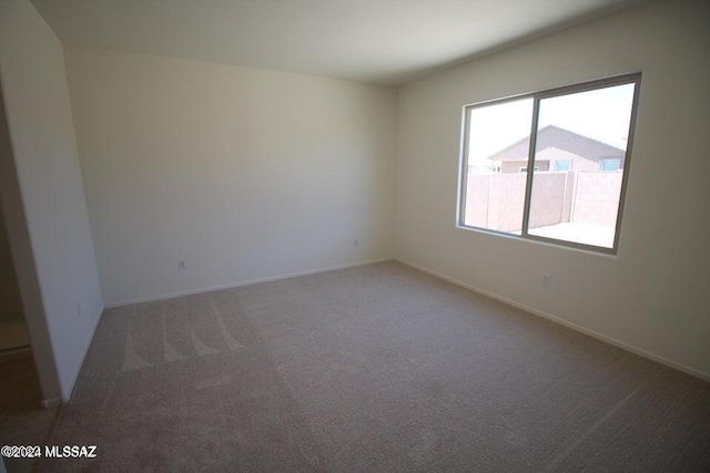 empty room with baseboards and carpet flooring