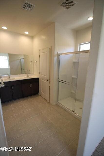 full bathroom with visible vents, a sink, and a shower stall