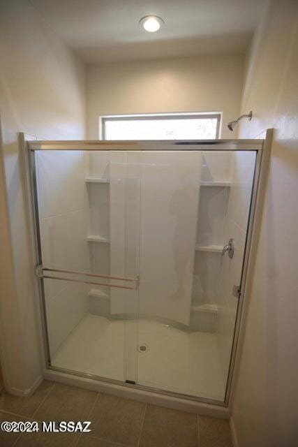 bathroom with a healthy amount of sunlight, tile patterned floors, and a stall shower