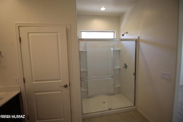 bathroom featuring vanity, baseboards, a shower stall, and tile patterned flooring