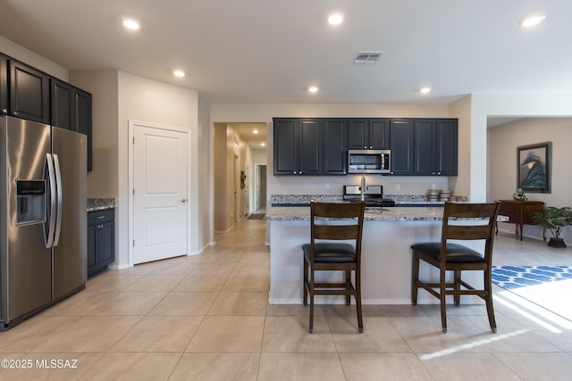 kitchen with visible vents, a kitchen bar, recessed lighting, light tile patterned floors, and stainless steel appliances