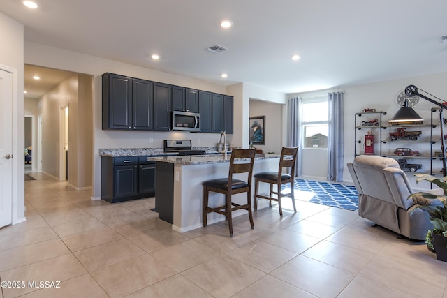 kitchen featuring visible vents, appliances with stainless steel finishes, light stone countertops, a breakfast bar, and recessed lighting