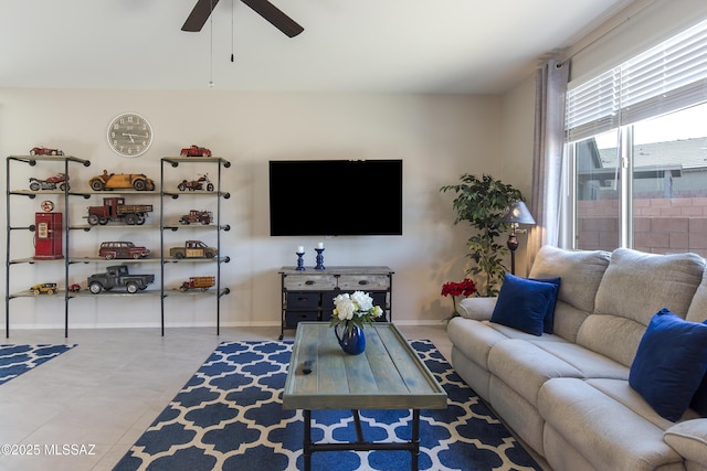 living room with baseboards and a ceiling fan