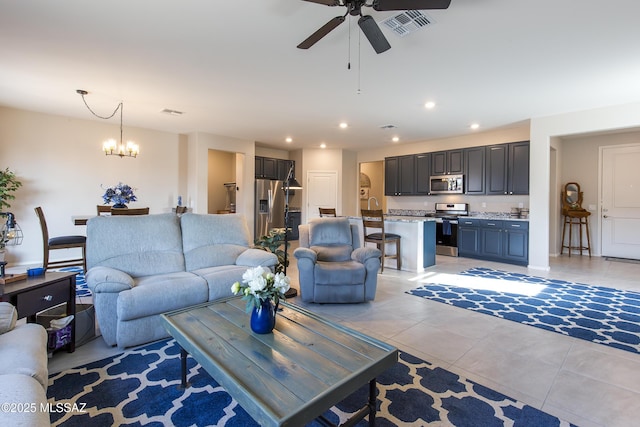 living area featuring visible vents, recessed lighting, ceiling fan with notable chandelier, and light tile patterned floors
