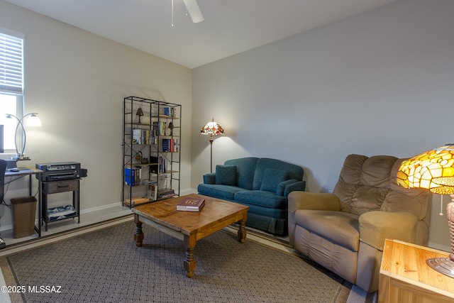 living area featuring ceiling fan and baseboards