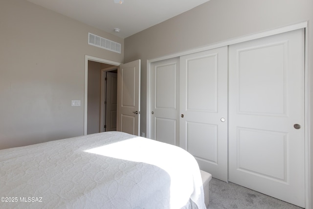 bedroom with light carpet, a closet, and visible vents