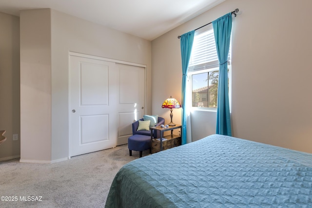 carpeted bedroom with baseboards and a closet